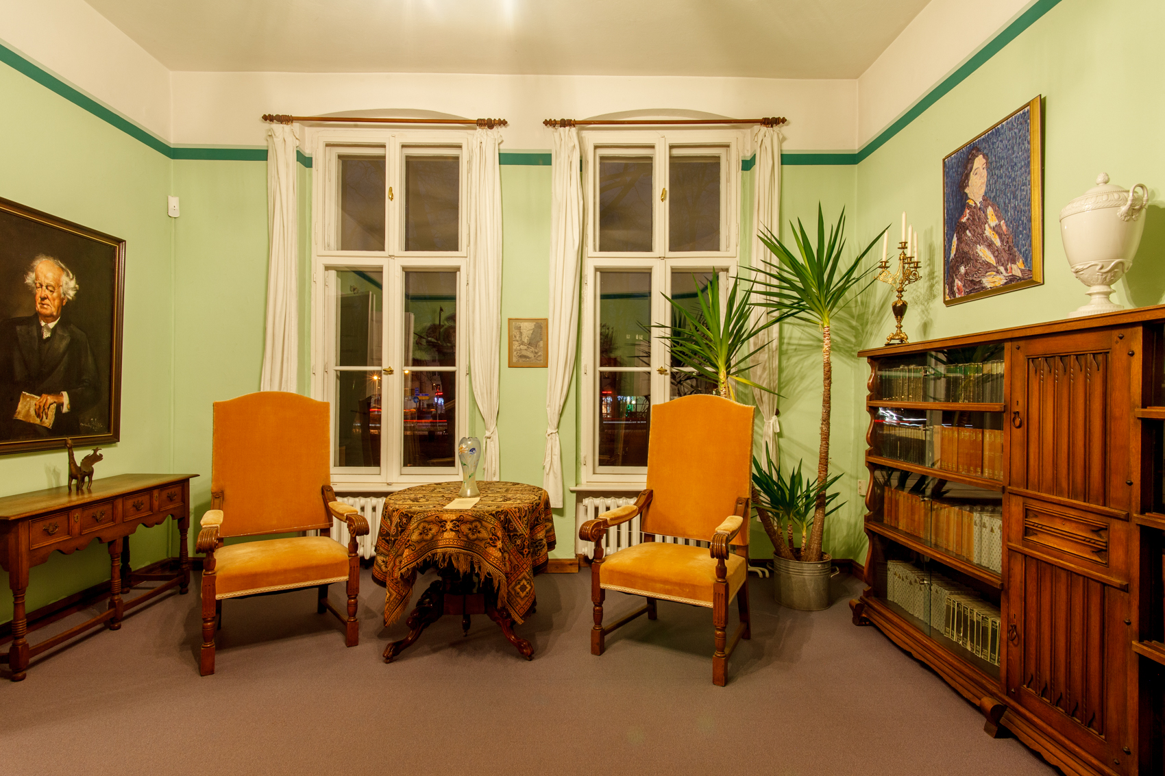 grün gestrichenes Zimmer in der Villa mit Samtstühlen und antiken Möbeln