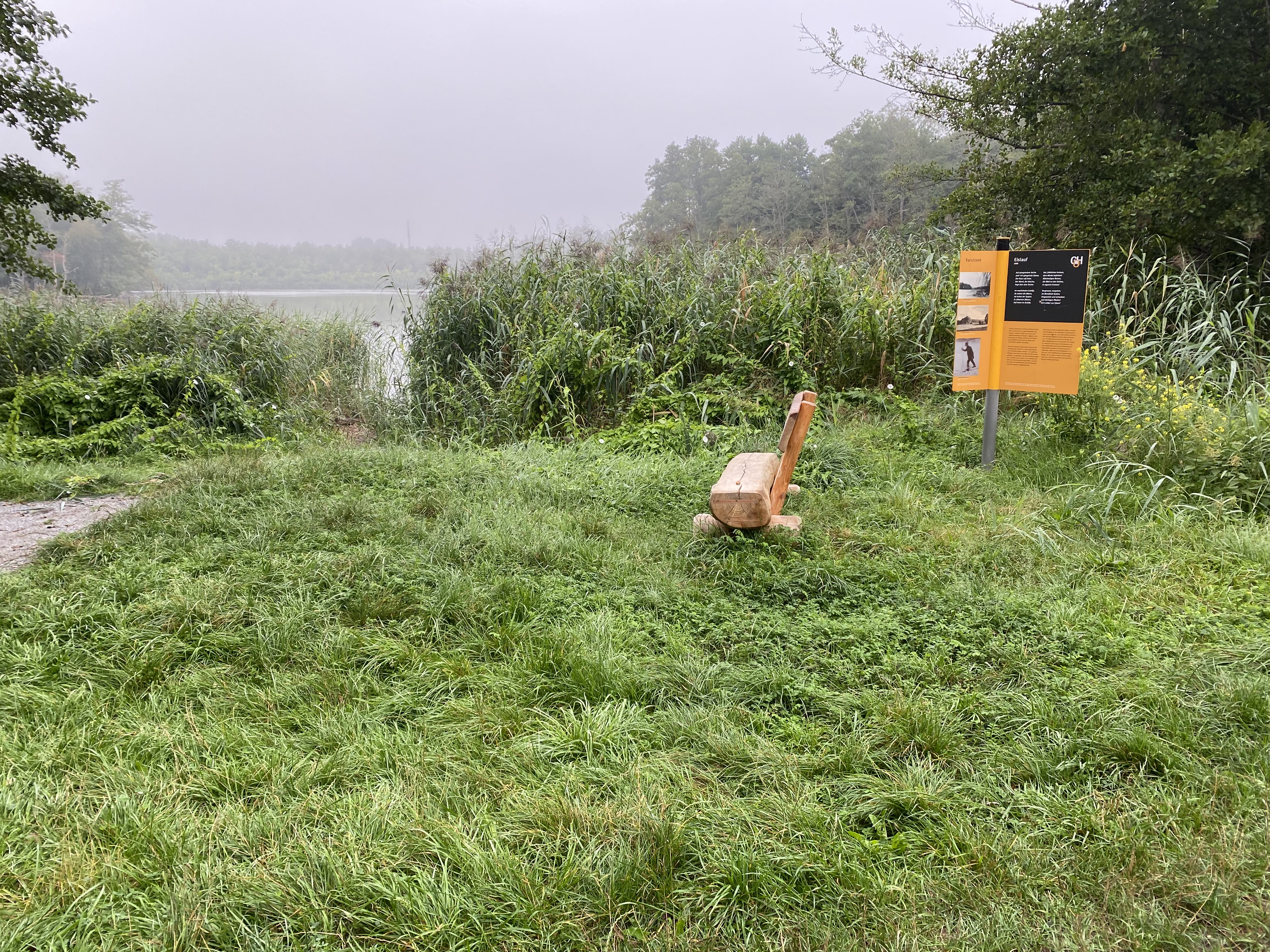 Infotafel und Holzbank am Karutzsee