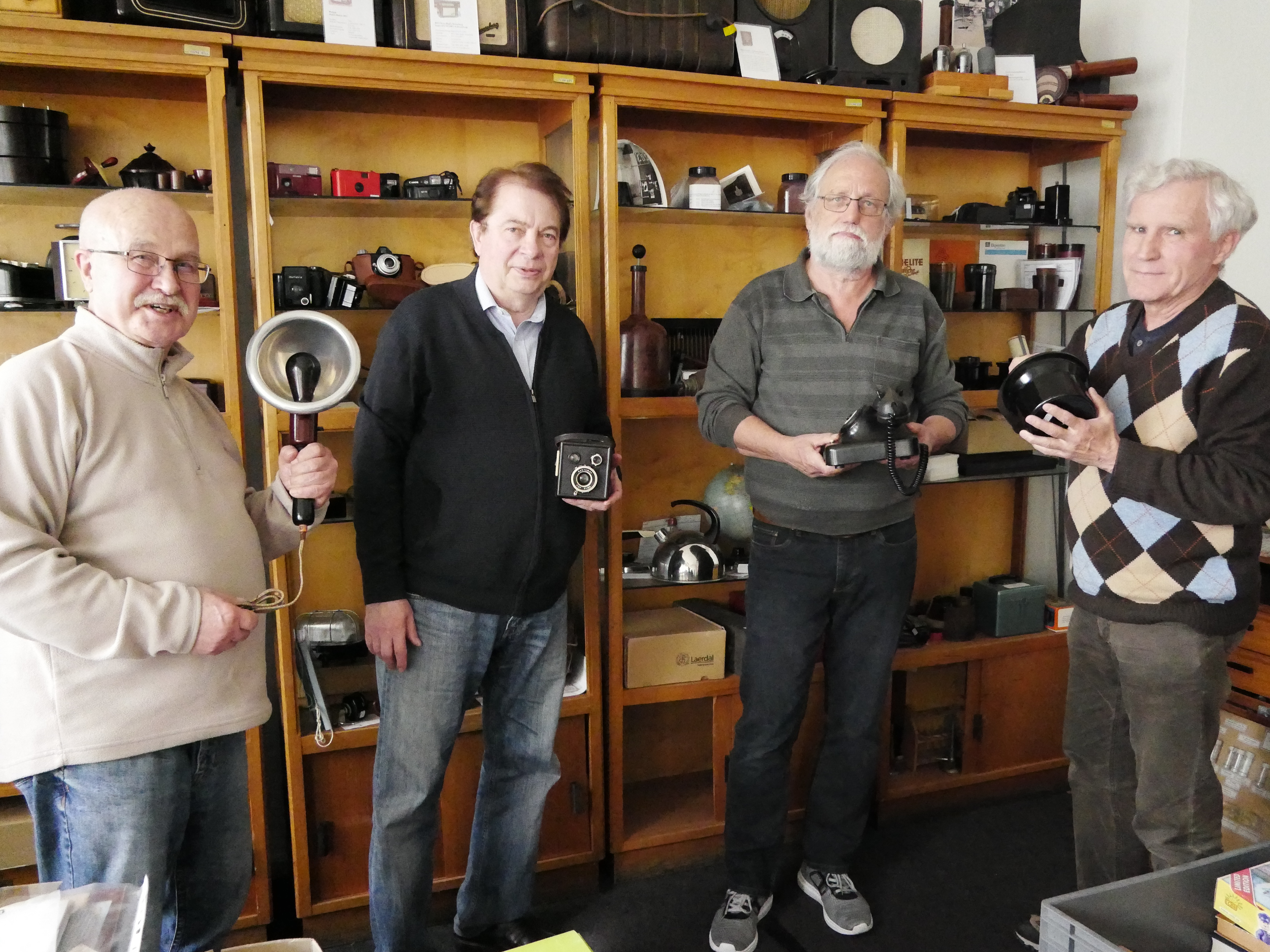 Die Vorstandsmitglieder des ChemieFreunde Erkner e. V. (v. l. n. r.: Joachim Schmidt, Prof. Dr. Hans Peter Welzel, Hubert Elsner und Prof. Dr. Jörg Friedrich) zeigen, was aus Bakelite alles produziert wurde. Um die 2.000 Ausstellungsstücke haben die Chemiker gesammelt.