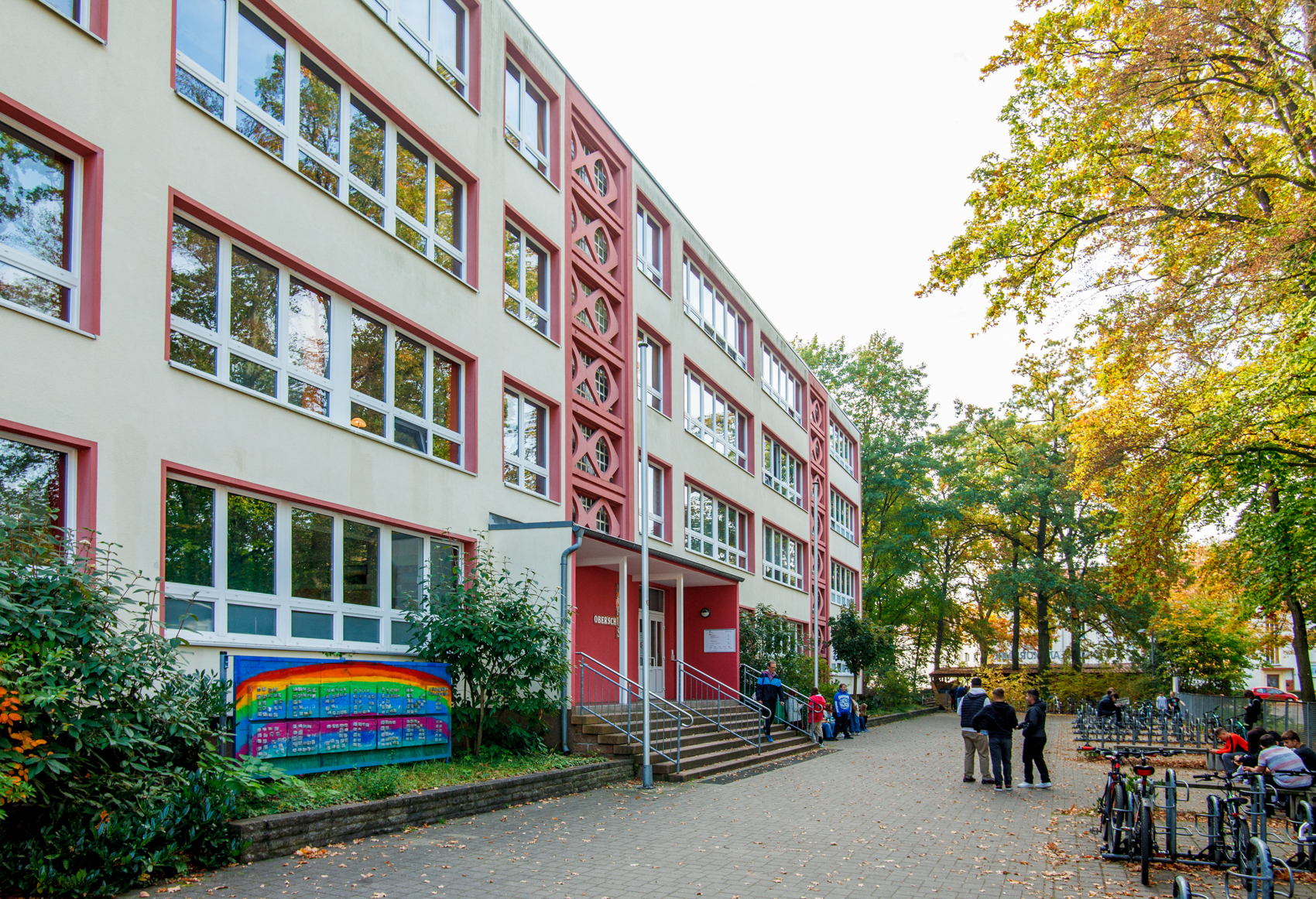 Schulgebäude mit roten Akzenten und Schulhof