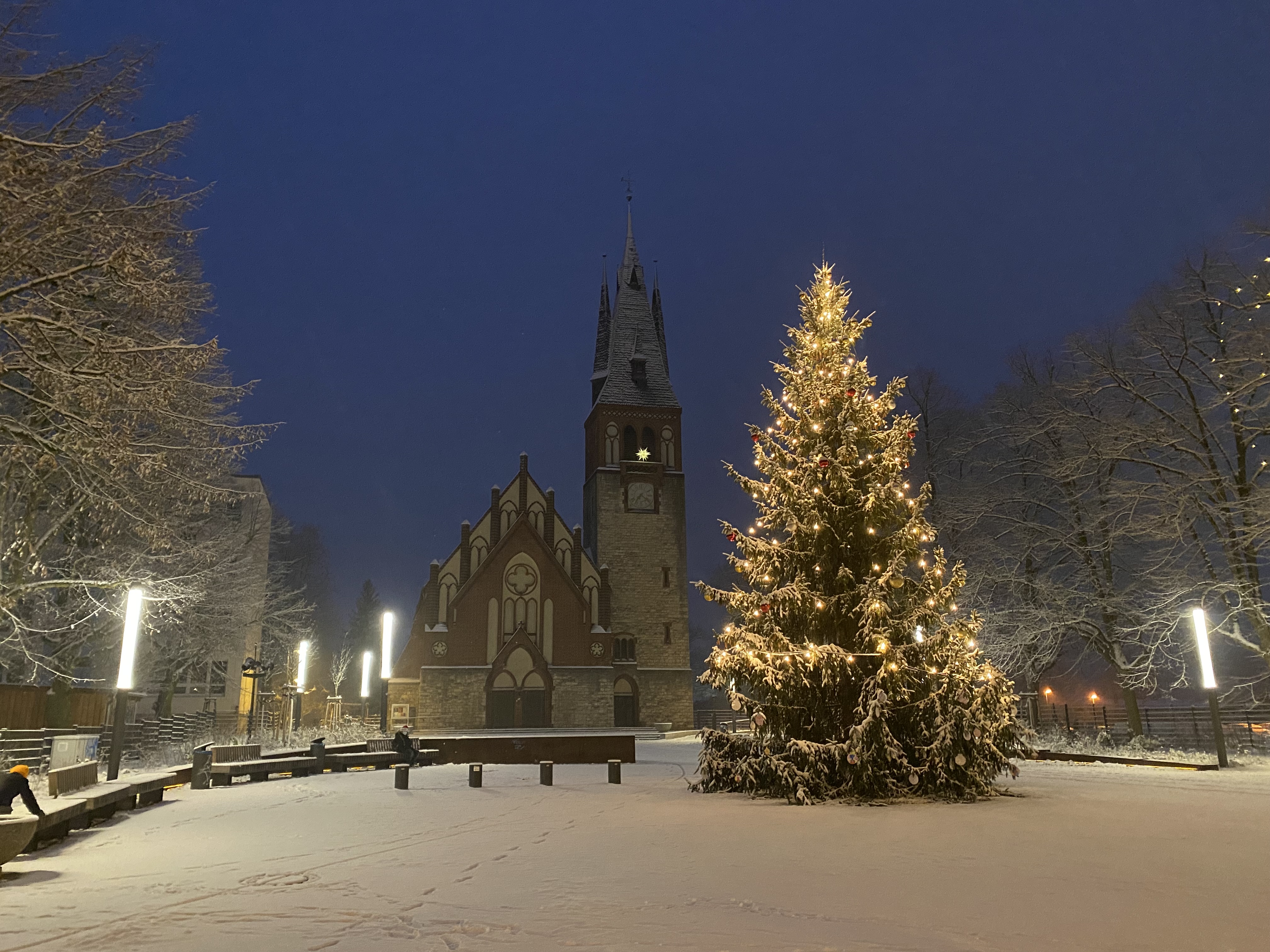 Verschneiter Kirchvorplatz mit Weihnachtsbaum