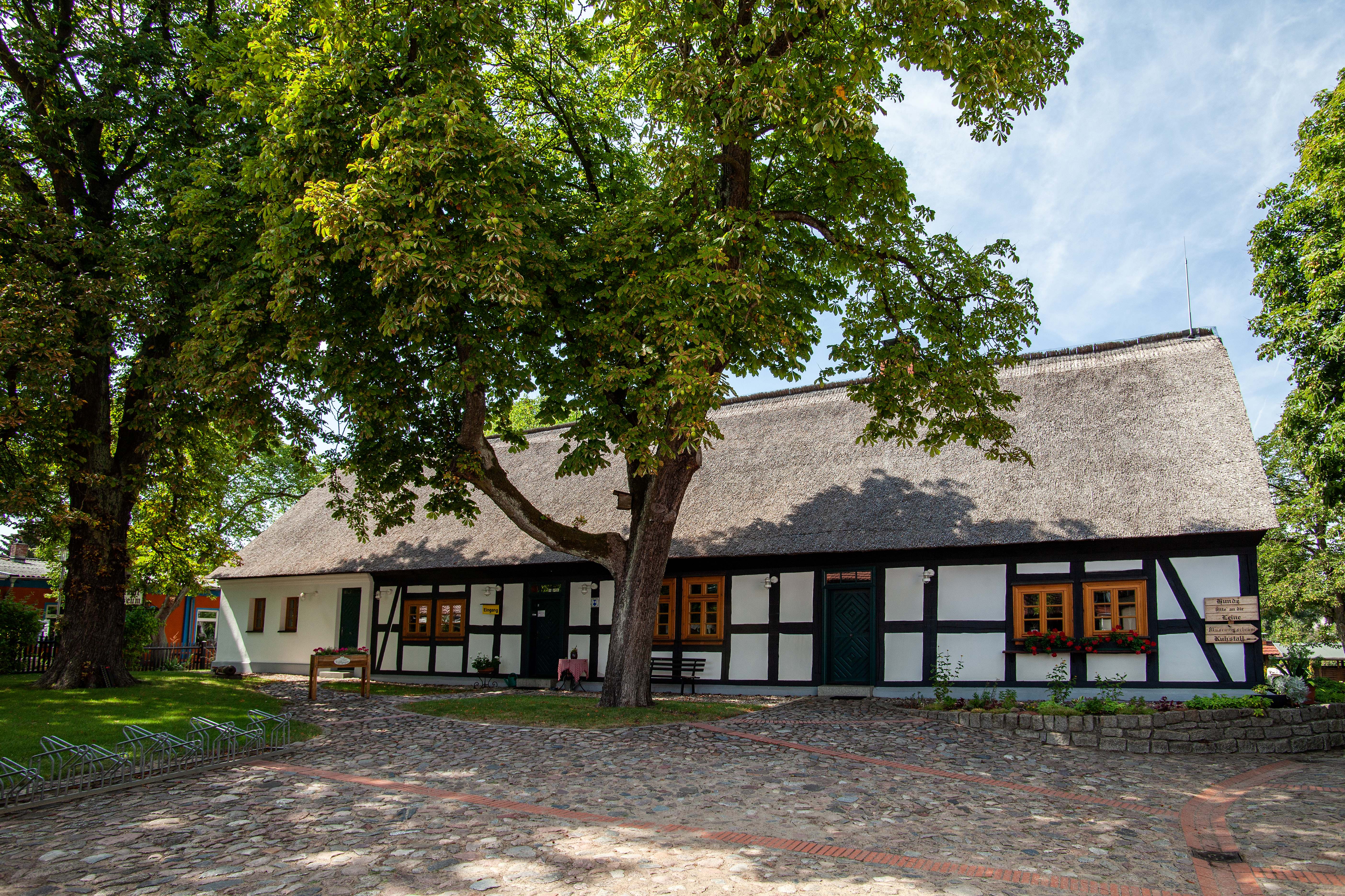denkmalgeschütztes Fachwerkhaus des Heimatmuseums mit baumgesäumten Hof