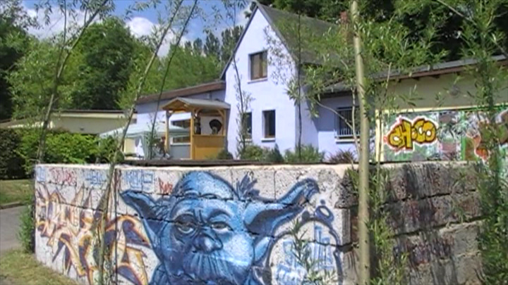 Jugendclub mit Graffiti-Mauer im Vordergrund
