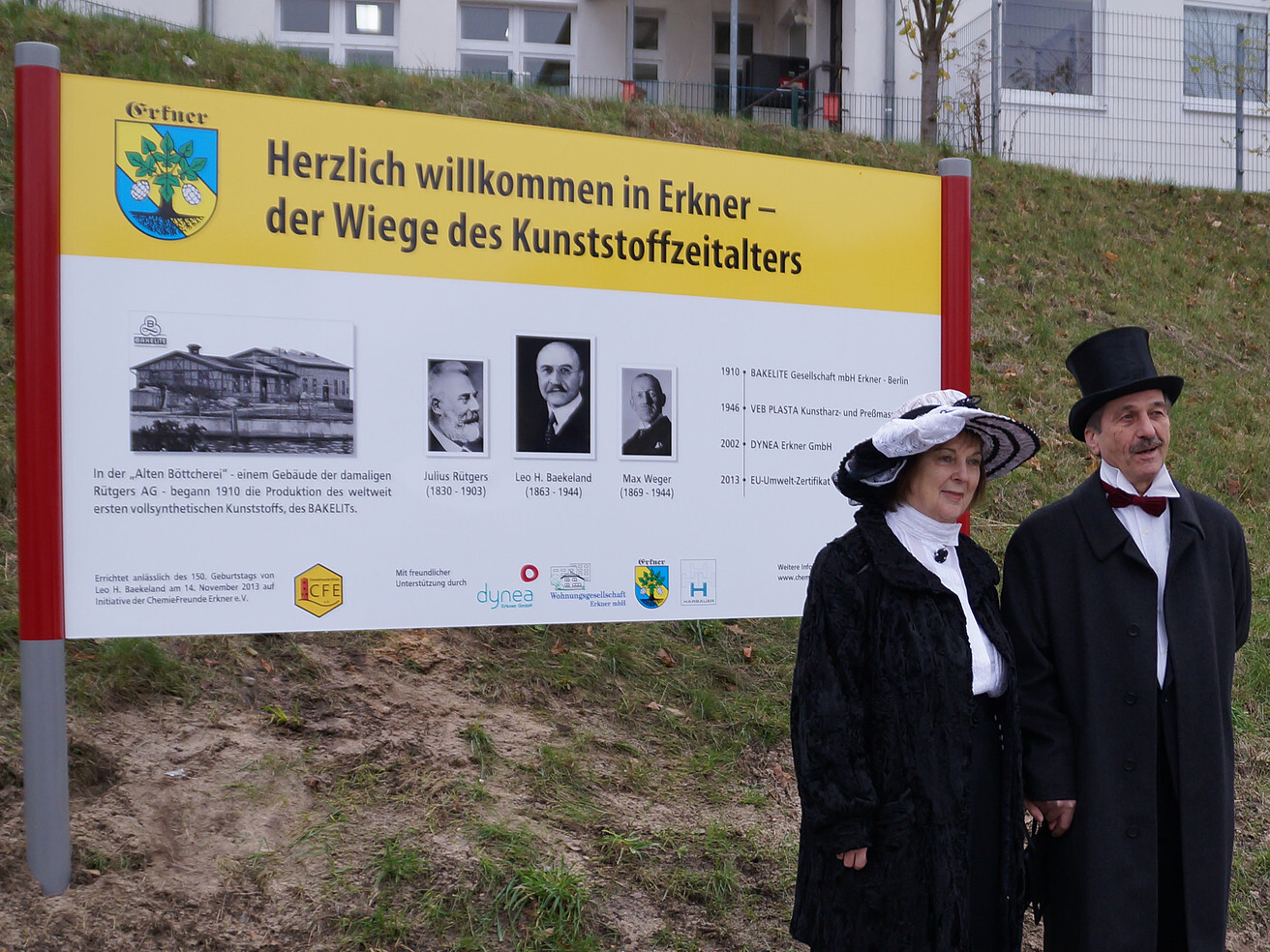 Historische Figuren vor Tafel zum Kunststoffzeitalter